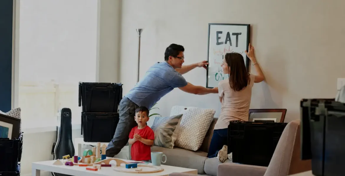 Family arranging wall art after moving