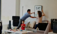 Family arranging wall art after moving